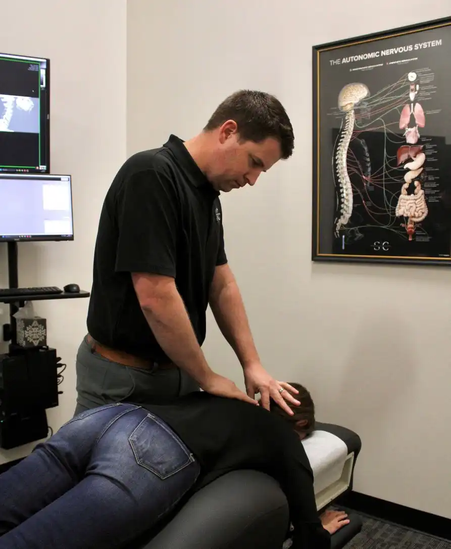 Dr. Stinson performing chiropractic adjustment on Bentonville patient near Crystal Bridges Museum and Walmart headquarters
